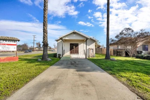a front view of a house with a yard and trees