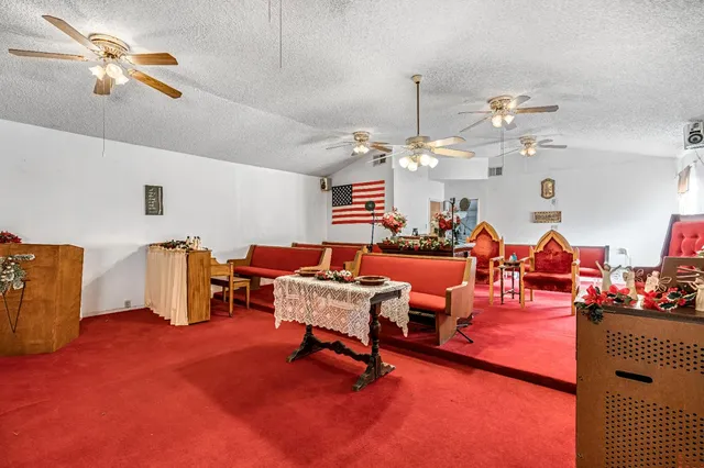 a living room with furniture kitchen view and a chandelier