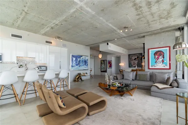a living room with furniture a couch and paintings on the wall