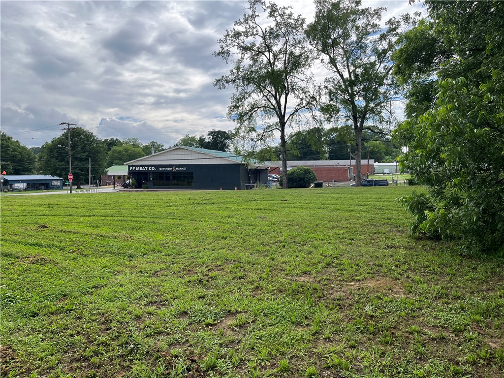 237 East Main Street Pendleton, SC 29670 - Photo 12 of 16 A spacious green expanse offers development potential near a commercial establishment.