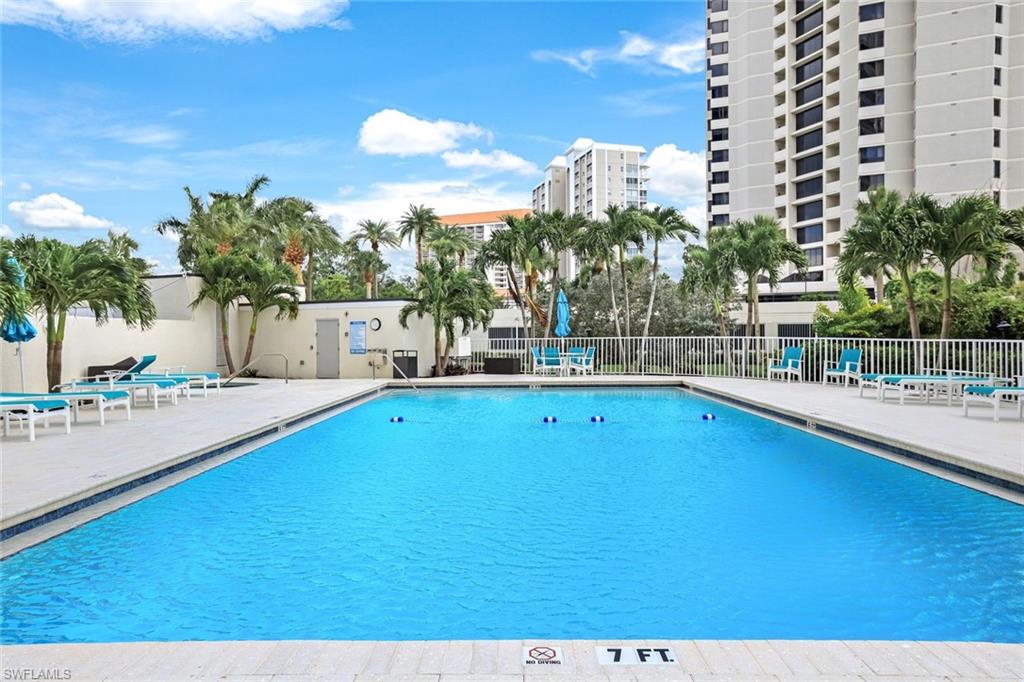 5550 Heron Point Drive, Unit 304 Naples, FL 34108 - Photo 17 of 19 a view of a swimming pool with a lawn chairs and potted plants