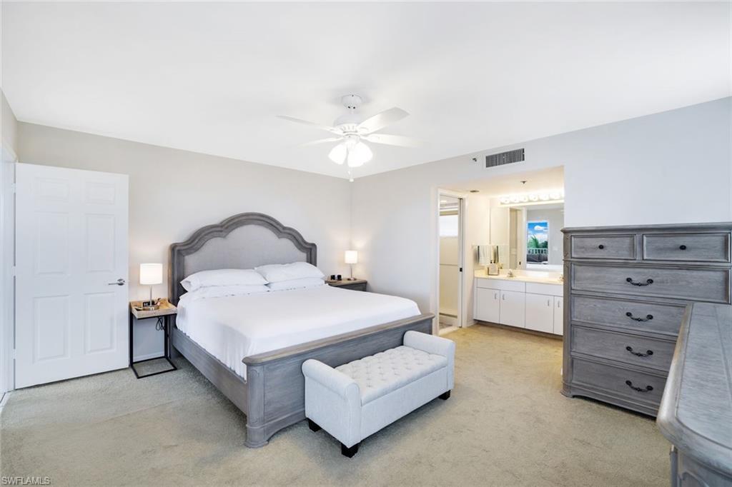 5550 Heron Point Drive, Unit 304 Naples, FL 34108 - Photo 7 of 19 a spacious bedroom with a bed and a ceiling fan