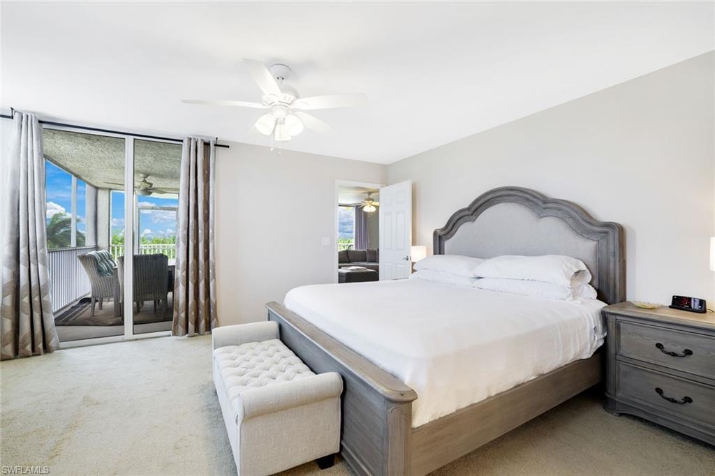 5550 Heron Point Drive, Unit 304 Naples, FL 34108 - Photo 8 of 19 a bedroom with a bed and a chandelier