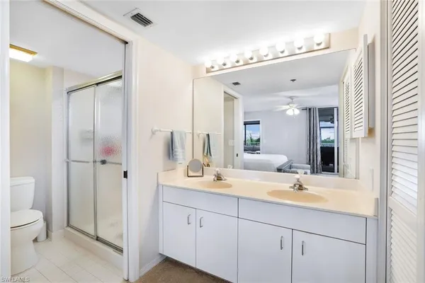 a bathroom with a double vanity sink mirror and toilet