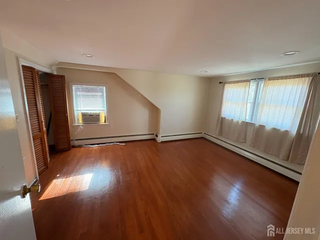 an empty room with closet and wooden floor