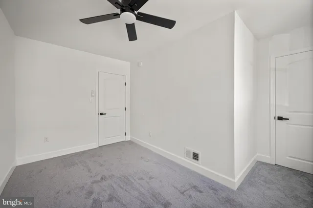 a view of an empty room with wooden floor and staircase