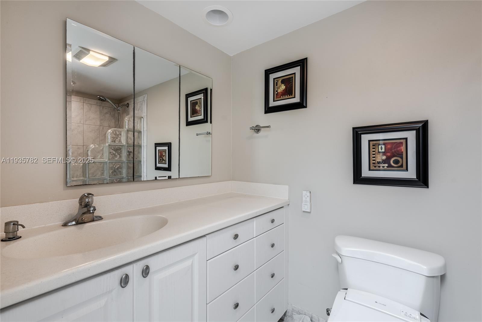 1401 South Federal Highway, Unit 122 Boca Raton, FL 33432 - Photo 9 of 20 a bathroom with a toilet sink and mirror