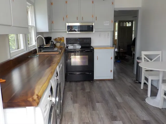 a kitchen with granite countertop a stove a sink and a refrigerator