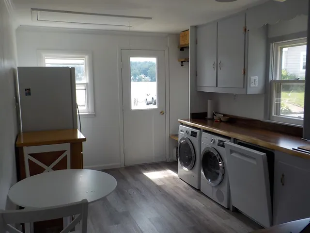 a kitchen with a table chairs a stove a sink and a window