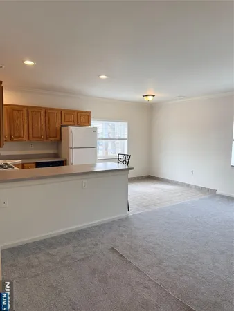 a kitchen with kitchen island granite countertop a stove a sink and a refrigerator