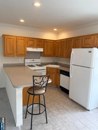 a kitchen with a table chairs a refrigerator and a sink
