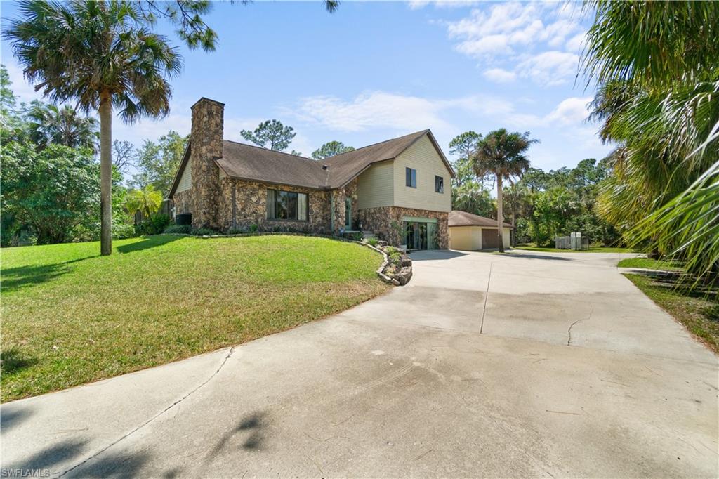 a view of a house with a yard and palm trees