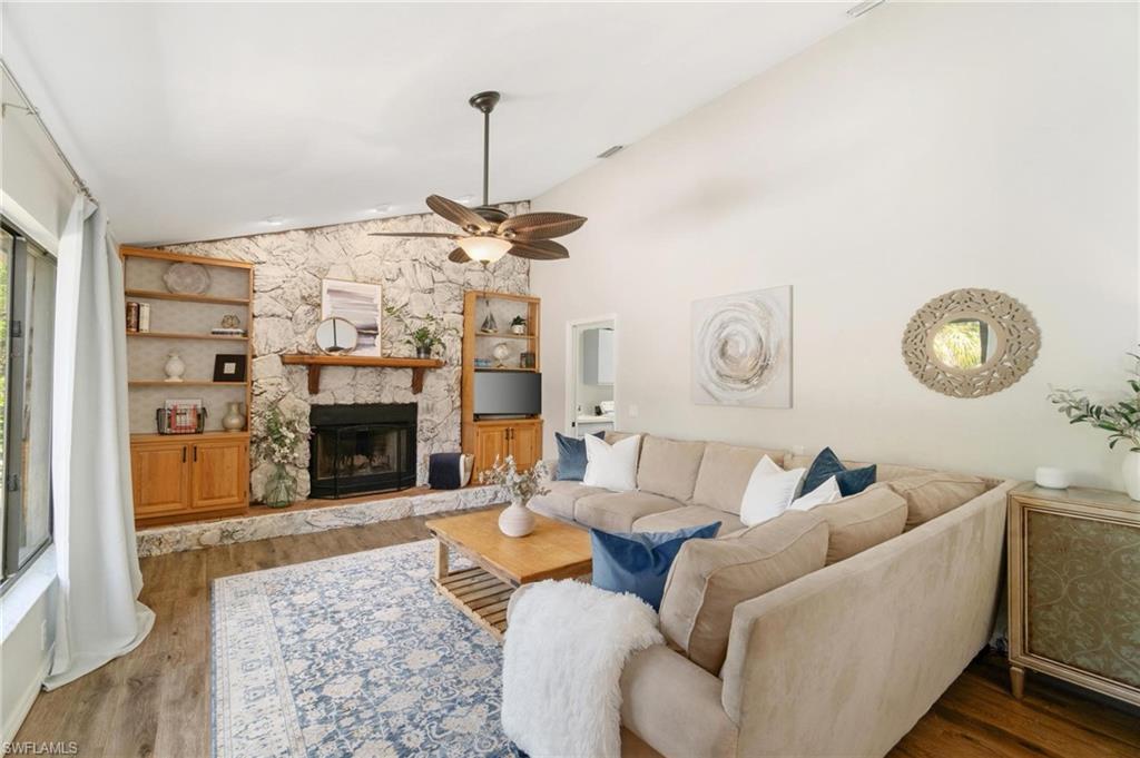 1041 29th Street Southwest Naples, FL 34117 - Photo 12 of 50 a living room with furniture a chandelier and a fireplace