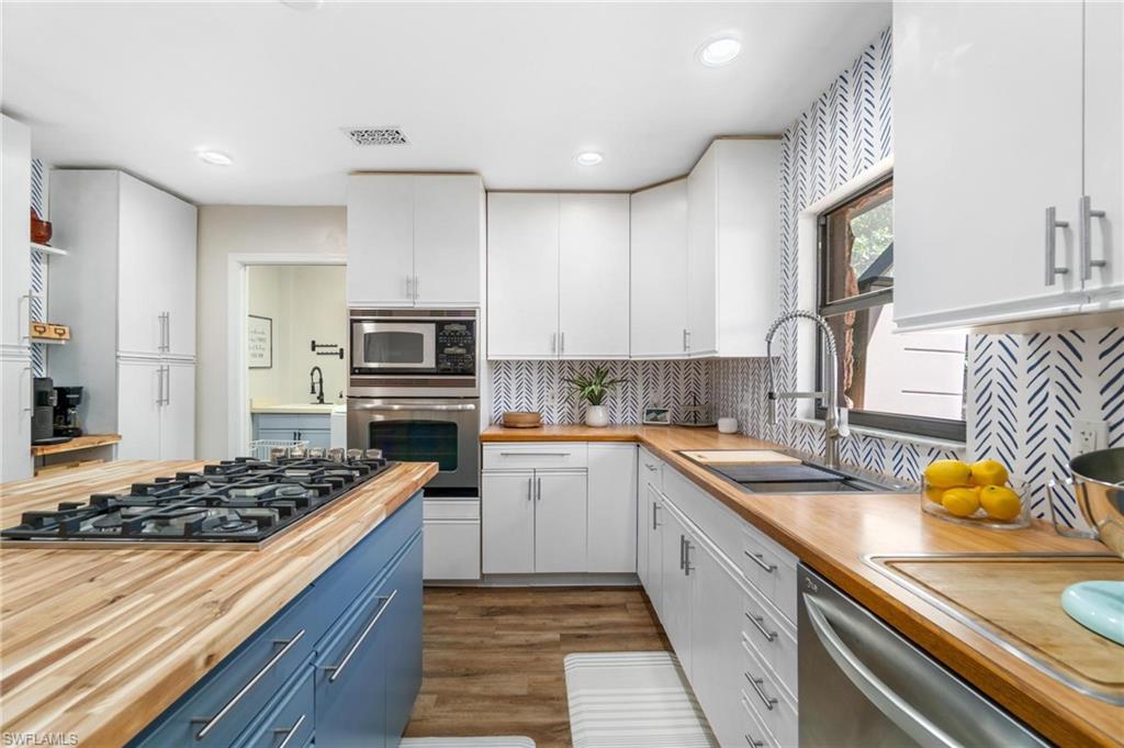 1041 29th Street Southwest Naples, FL 34117 - Photo 16 of 50 a kitchen with stainless steel appliances kitchen island granite countertop a sink stove and refrigerator
