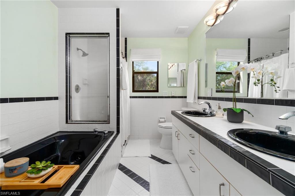 1041 29th Street Southwest Naples, FL 34117 - Photo 25 of 50 a bathroom with a sink and a large mirror
