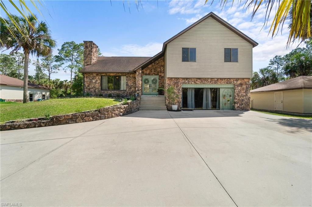 1041 29th Street Southwest Naples, FL 34117 - Photo 3 of 50 a front view of a house with a yard and garage