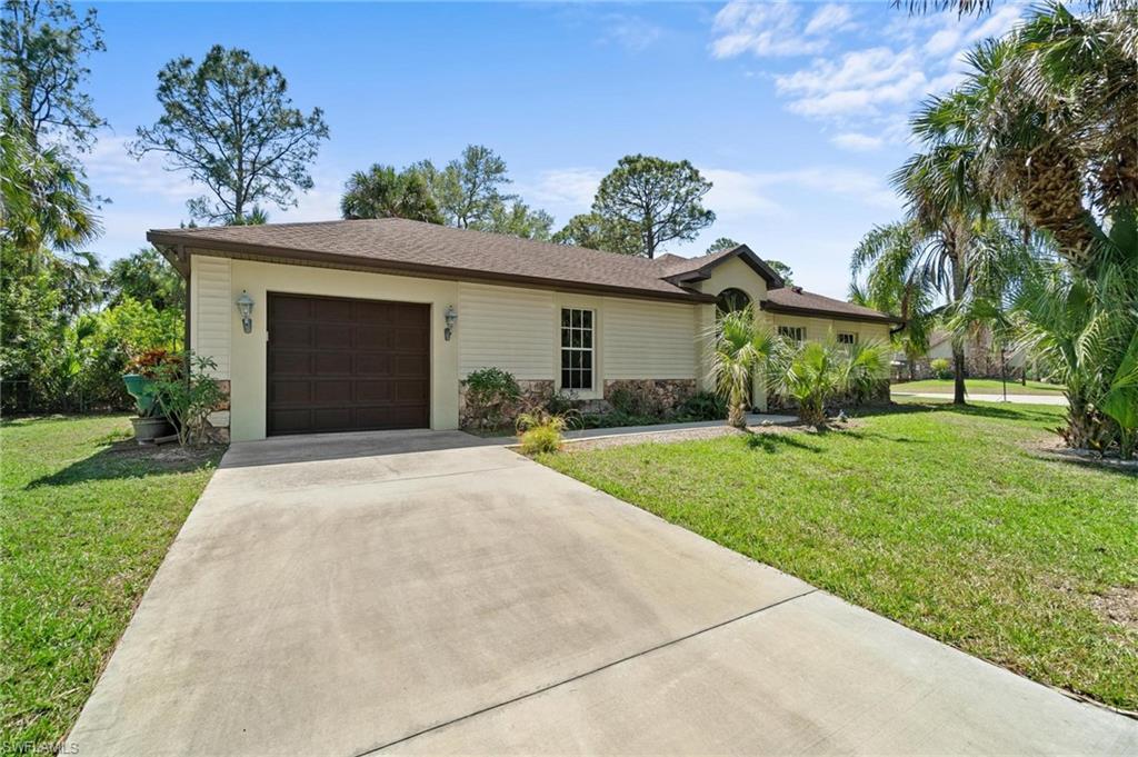 1041 29th Street Southwest Naples, FL 34117 - Photo 34 of 50 a front view of a house with a yard and potted plants