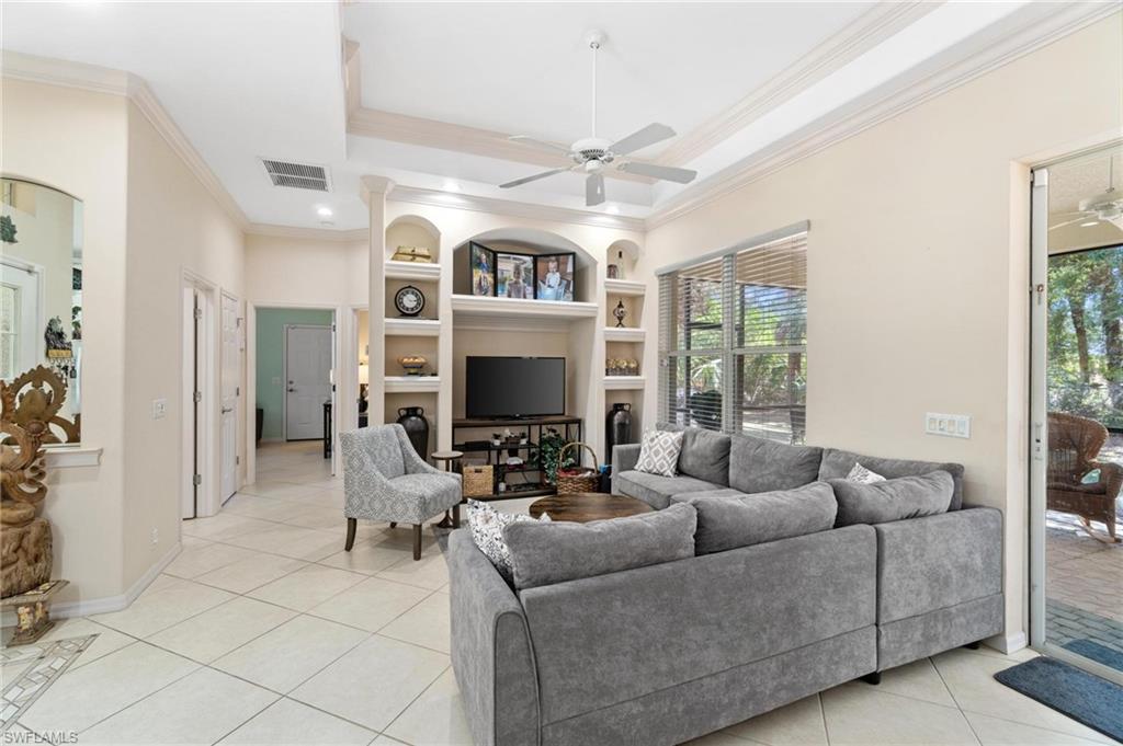 1041 29th Street Southwest Naples, FL 34117 - Photo 36 of 50 a living room with furniture a flat screen tv and a large window