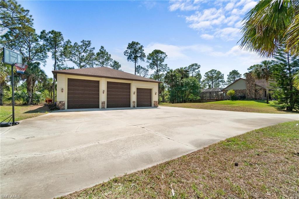 1041 29th Street Southwest Naples, FL 34117 - Photo 7 of 50 a front view of a house with a yard and garage