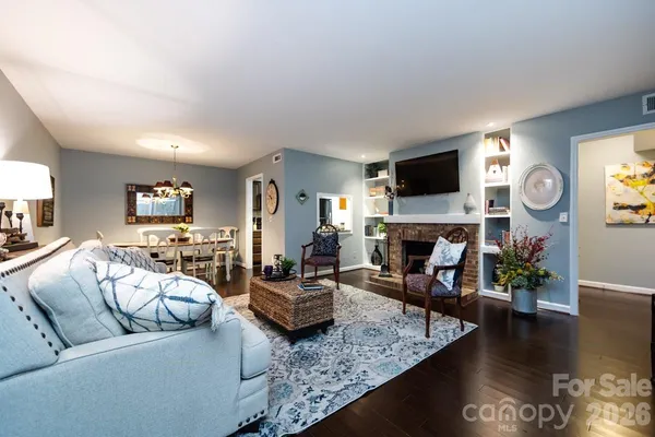 a living room with furniture a fireplace and a flat screen tv