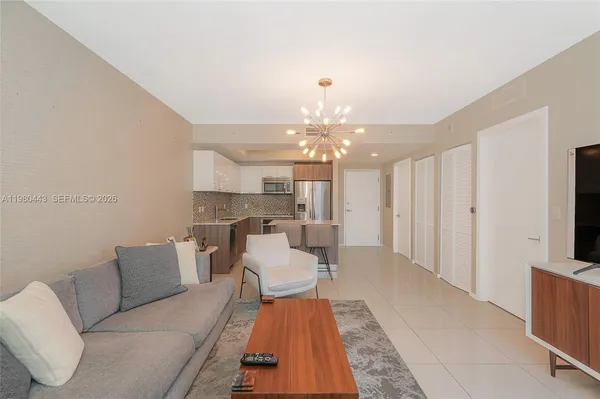 a kitchen with stainless steel appliances kitchen island granite countertop a table chairs and a refrigerator