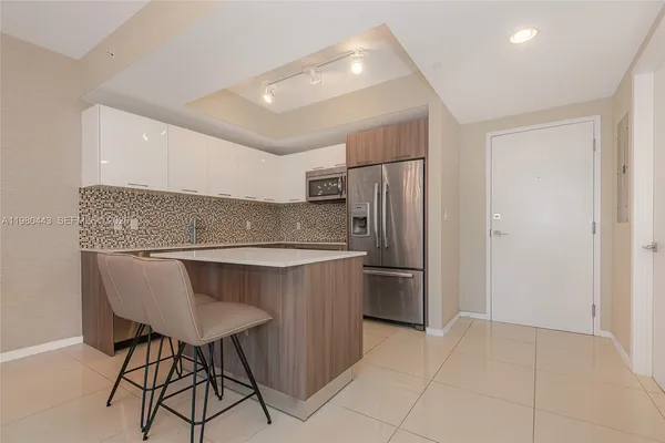 a kitchen with stainless steel appliances granite countertop a refrigerator and a sink