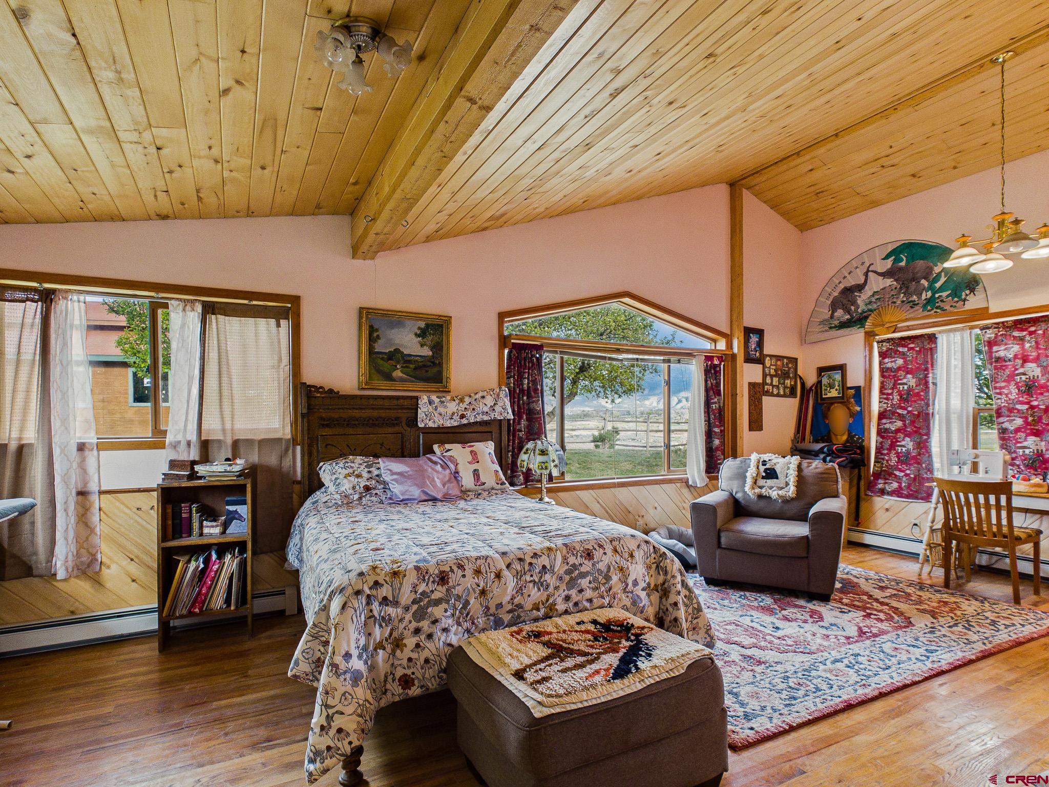 37760 Back River Road Paonia, CO 81428 - Photo 30 of 38 a bedroom with a bed a couch and wooden floor