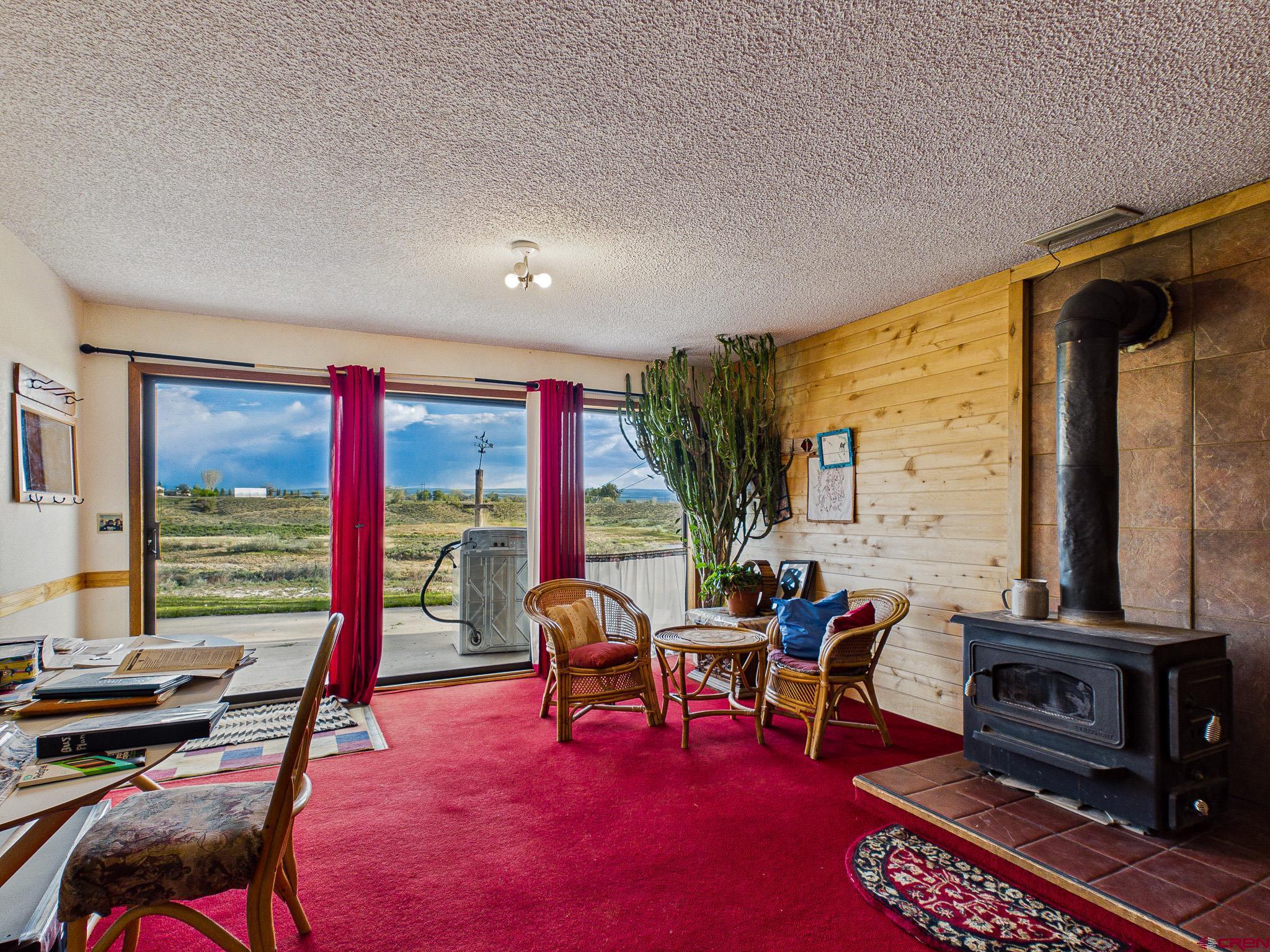 37760 Back River Road Paonia, CO 81428 - Photo 33 of 38 a living room with furniture a flat screen tv and a floor to ceiling window