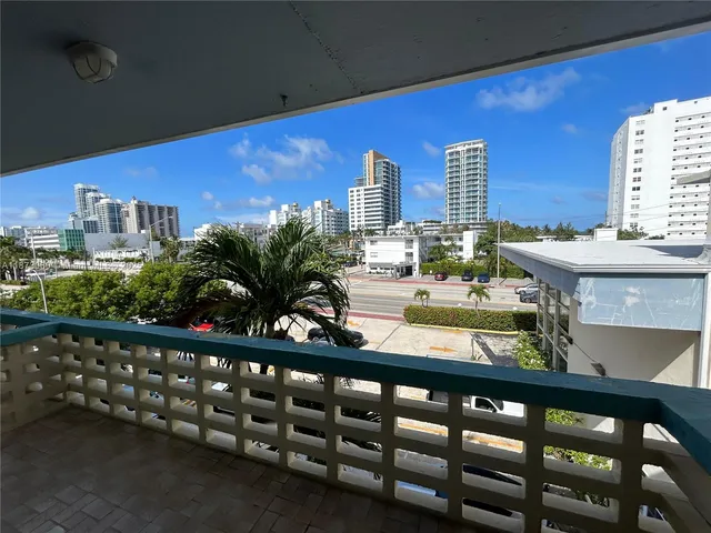 a view of a balcony with chairs and wooden fence