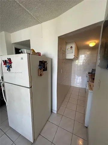 a white refrigerator freezer and a stove sitting inside of a kitchen