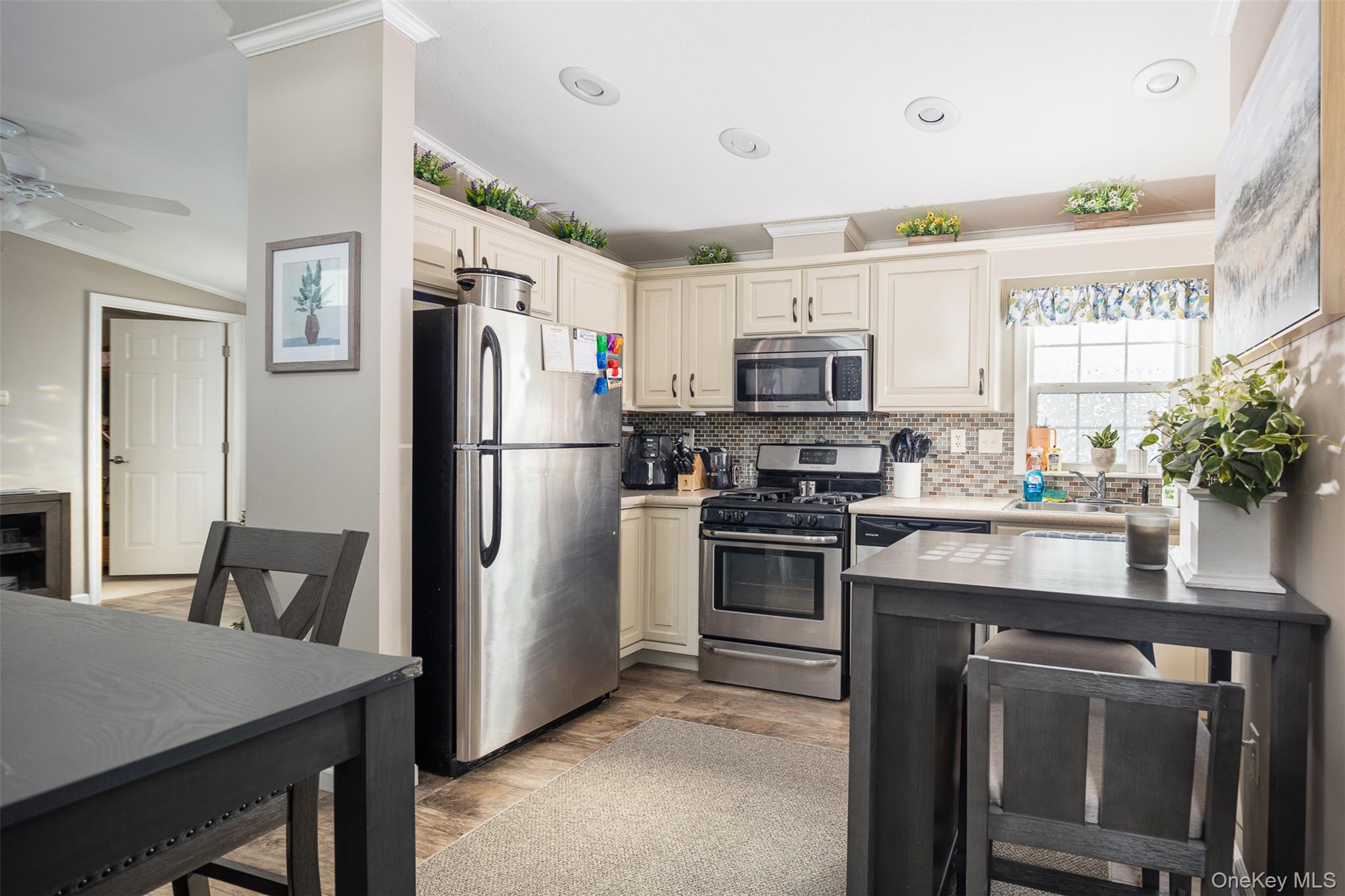 1661 Old Country Road, Unit 181 GLYNWOOD Riverhead, NY 11901 - Photo 3 of 13 a kitchen with stainless steel appliances a refrigerator stove microwave and sink
