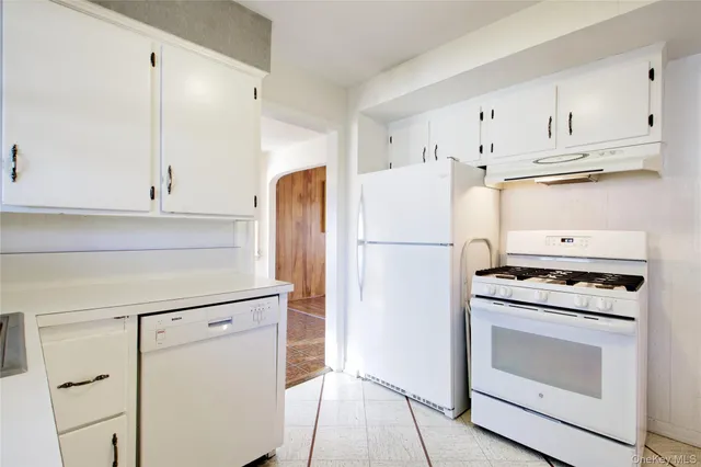a kitchen with cabinets appliances and wooden floor