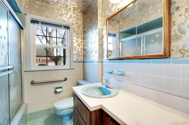 a bathroom with a sink toilet and window