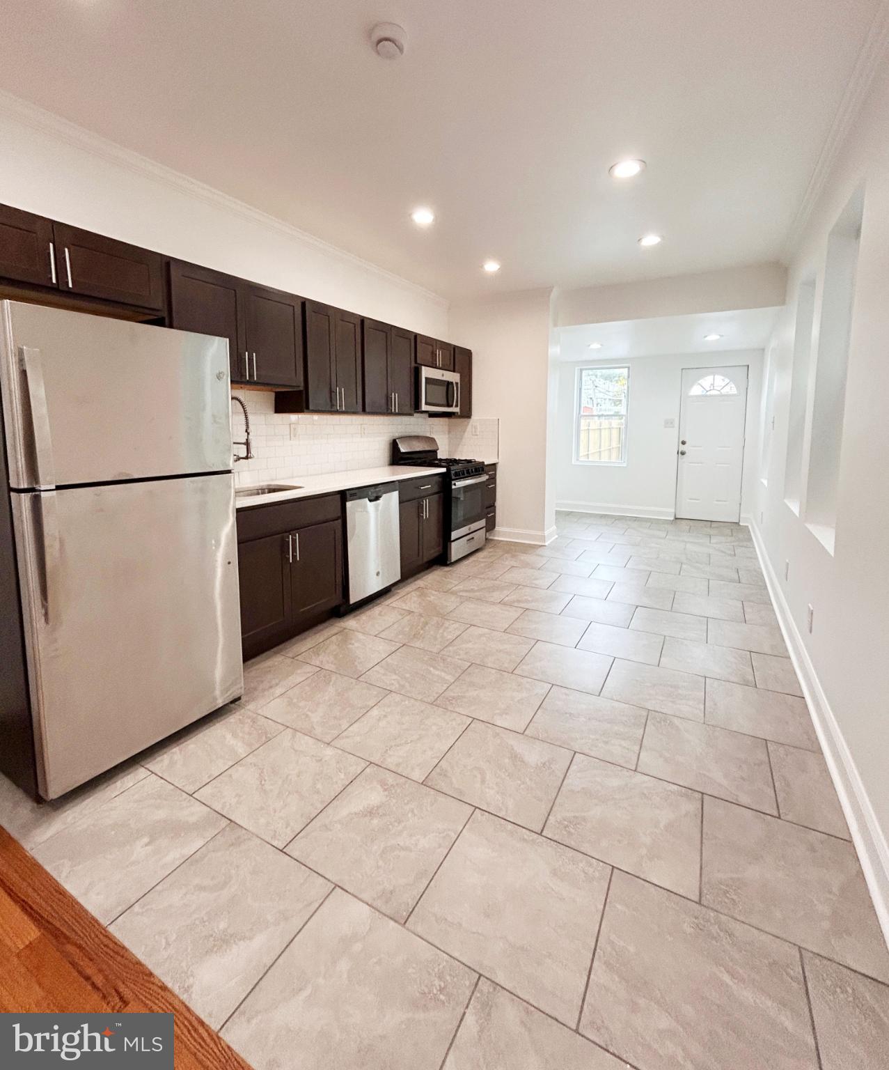 a kitchen with stainless steel appliances a refrigerator sink and cabinets