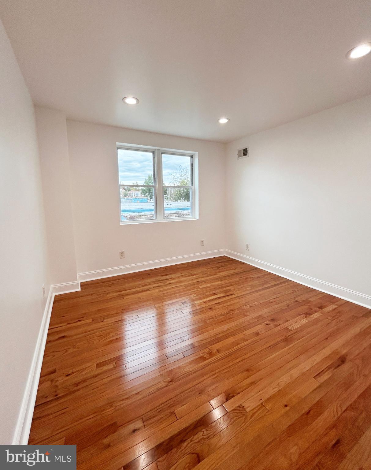 1241 Orthodox Street Philadelphia, PA 19124 - Photo 15 of 26 an empty room with wooden floor and windows