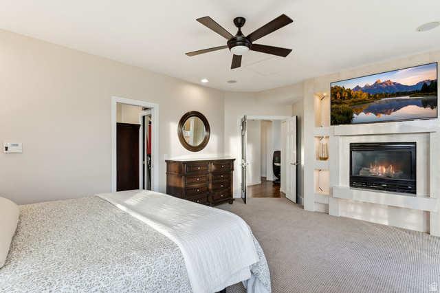 1878 East Ridge Point Drive Bountiful, UT 84010 - Photo 22 of 92 Carpeted bedroom featuring a ceiling fan, a glass covered fireplace, and recessed lighting