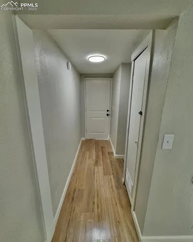 a view of a hallway in a house with wooden floor