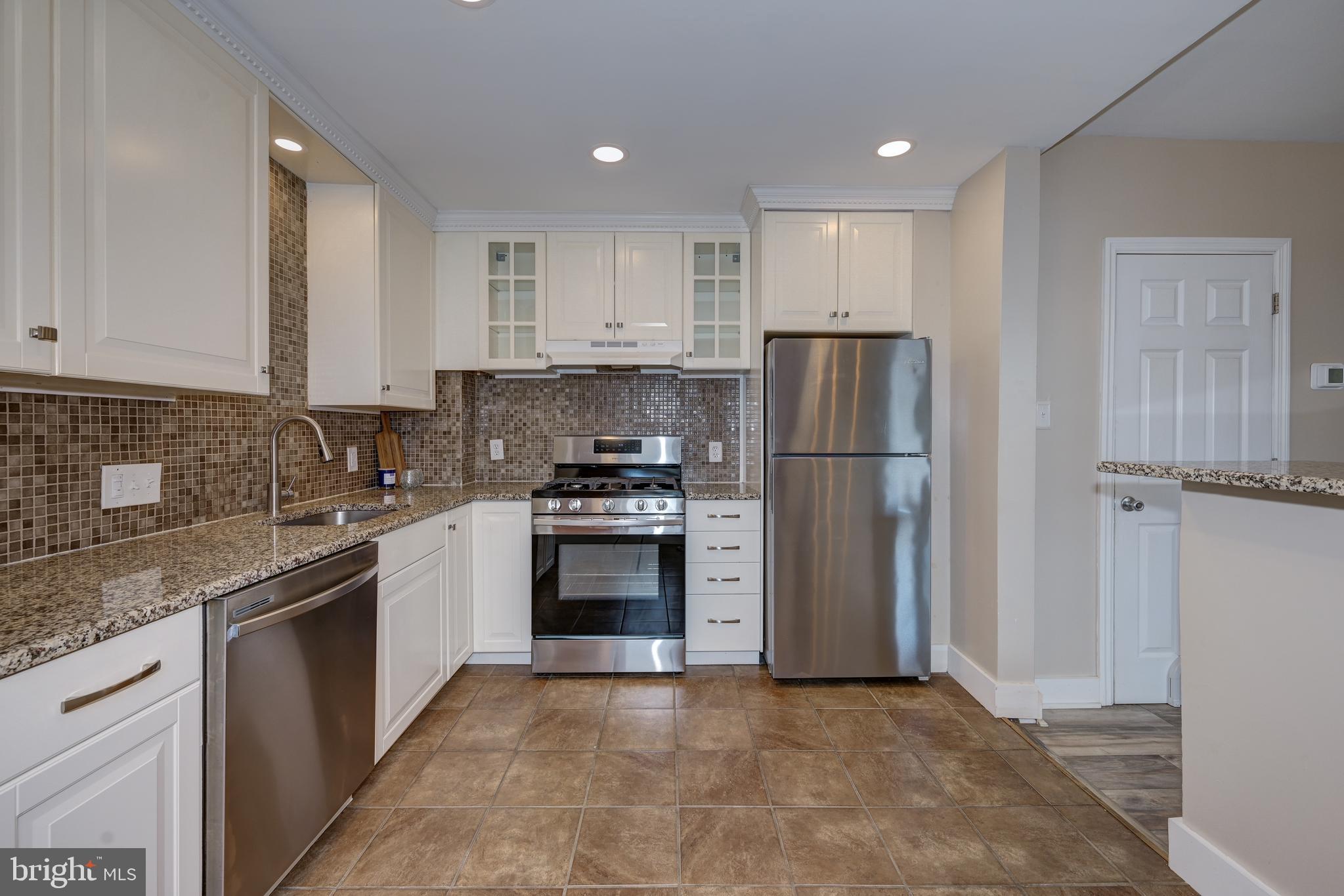 323 Cleveland Avenue Riverside, NJ 08075 - Photo 22 of 36 a kitchen with a refrigerator sink and cabinets