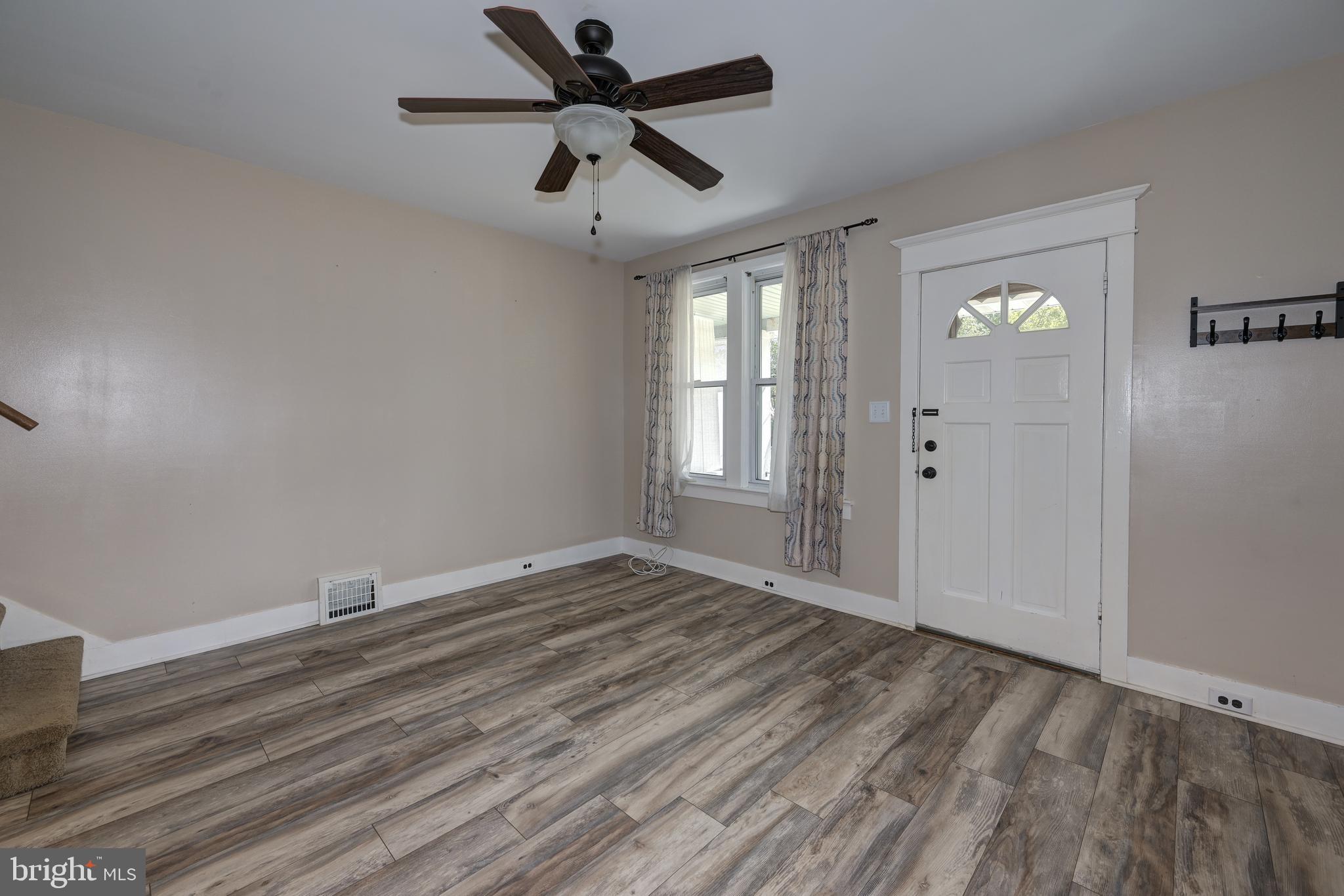 323 Cleveland Avenue Riverside, NJ 08075 - Photo 10 of 36 an empty room with wooden floor and windows