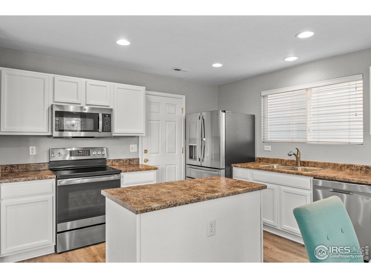 10688 Durango Place Longmont, CO 80504 - Photo 13 of 49 a kitchen with stainless steel appliances granite countertop a stove a sink a microwave a refrigerator and white cabinets