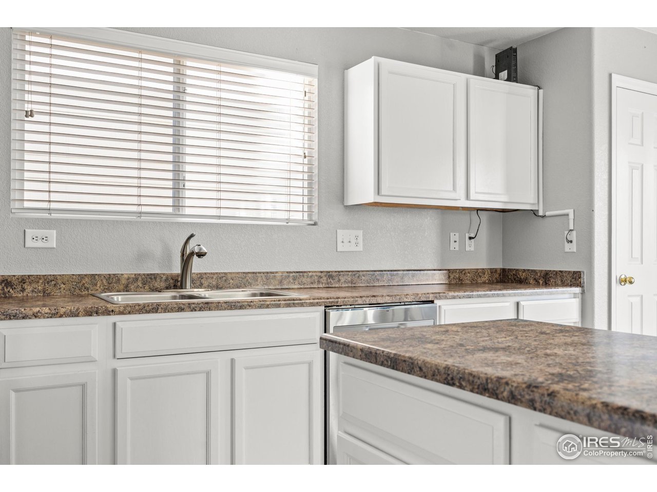 10688 Durango Place Longmont, CO 80504 - Photo 47 of 49 a kitchen with granite countertop white cabinets and a sink
