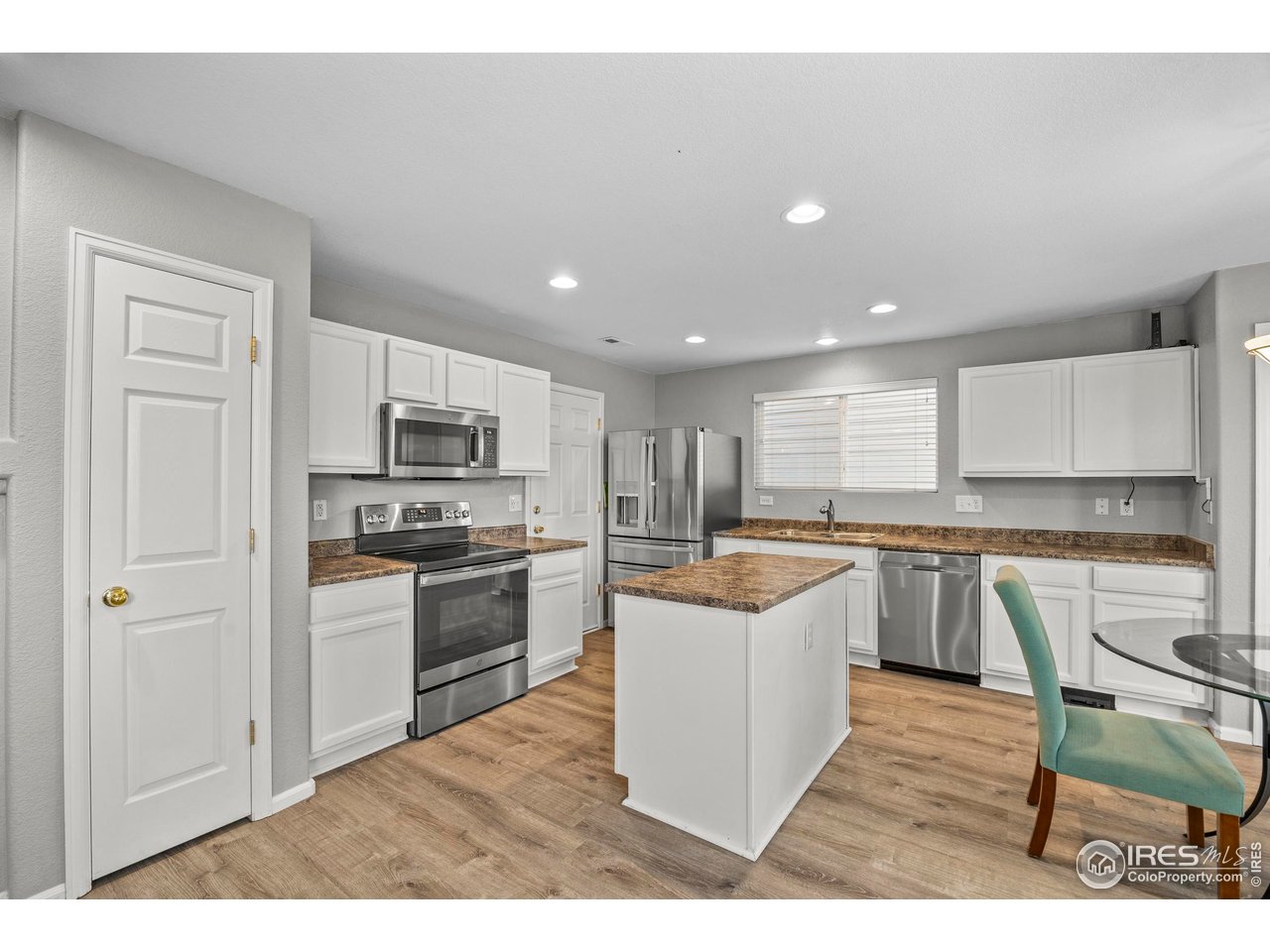 10688 Durango Place Longmont, CO 80504 - Photo 9 of 49 a kitchen with white cabinets and stainless steel appliances