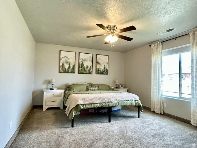 310 625 East Enterprise, UT 84725 - Photo 34 of 36 Spacious room featuring carpeting, a ceiling fan with light fixture, and a large window