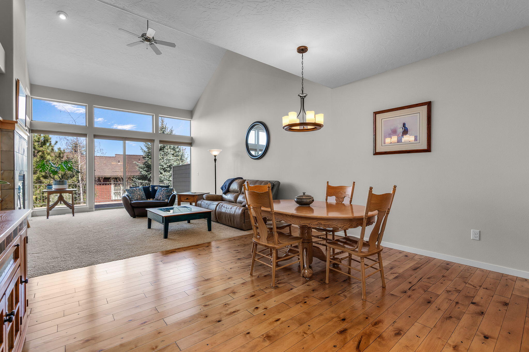10870 Village Loop Redmond, OR 97756 - Photo 3 of 35 a dining room with wooden floor a chandelier a wooden table and chairs