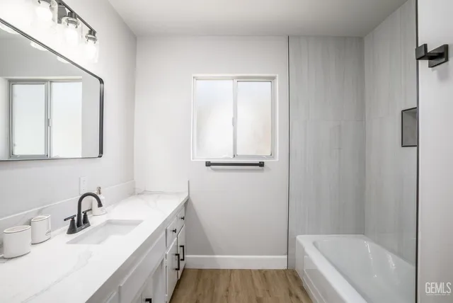 a bathroom with a tub sink toilet and mirror