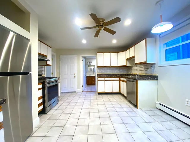 a kitchen with granite countertop a refrigerator and a stove top oven