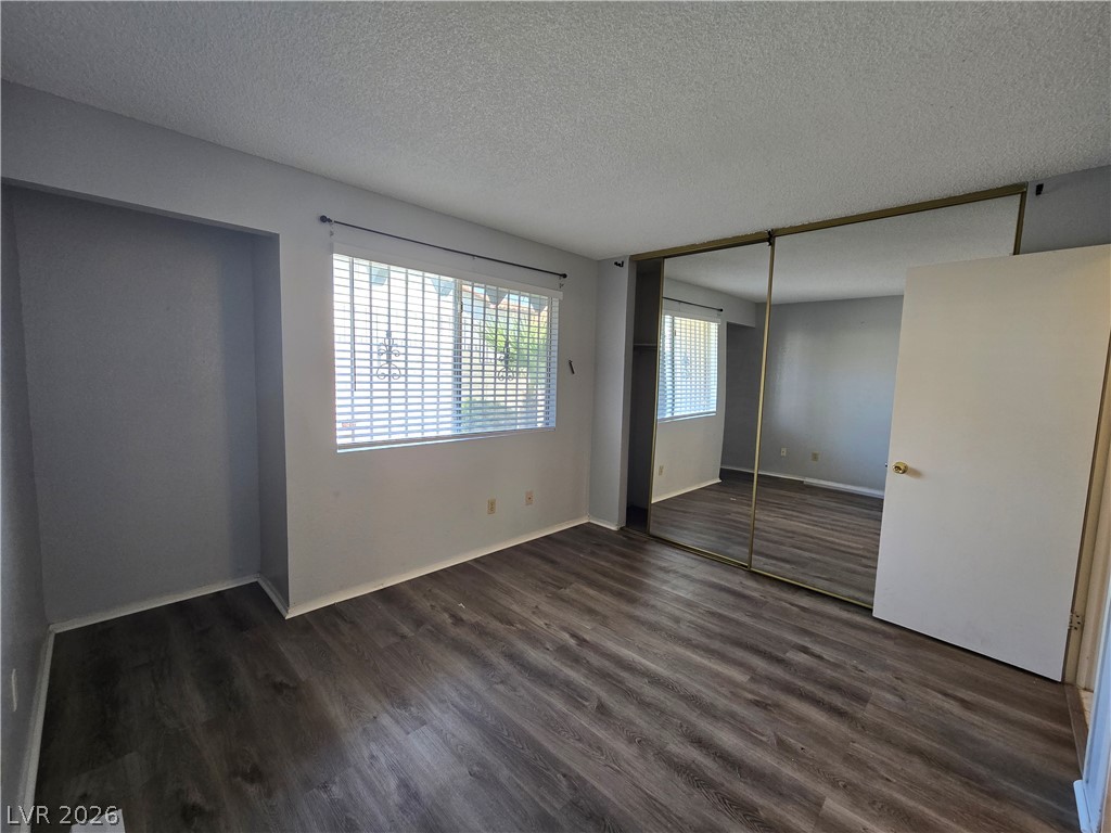 6750 Del Rey Avenue, Unit 133 Las Vegas, NV 89146 - Photo 16 of 34 Well-lit sleeping quarters with rich wood-like flooring, complete with convenient mirrored closet doors.