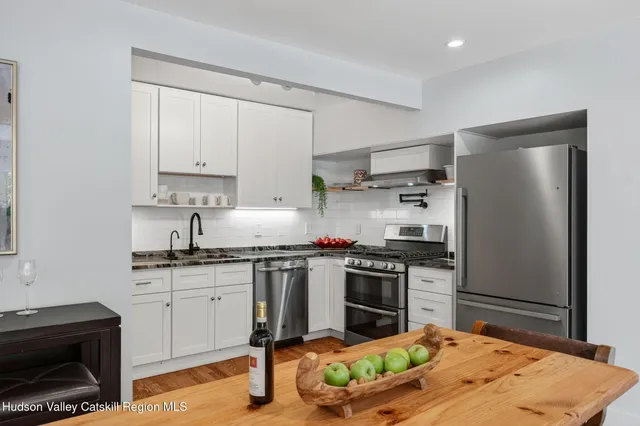 a kitchen with cabinets stainless steel appliances and wooden floor
