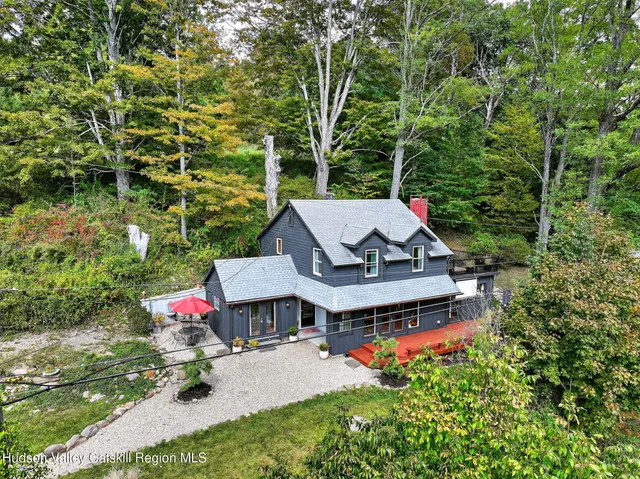 an aerial view of a house with swimming pool garden view and trees