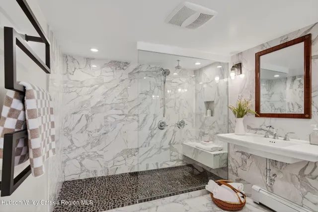 a bathroom with a sink shower and a mirror